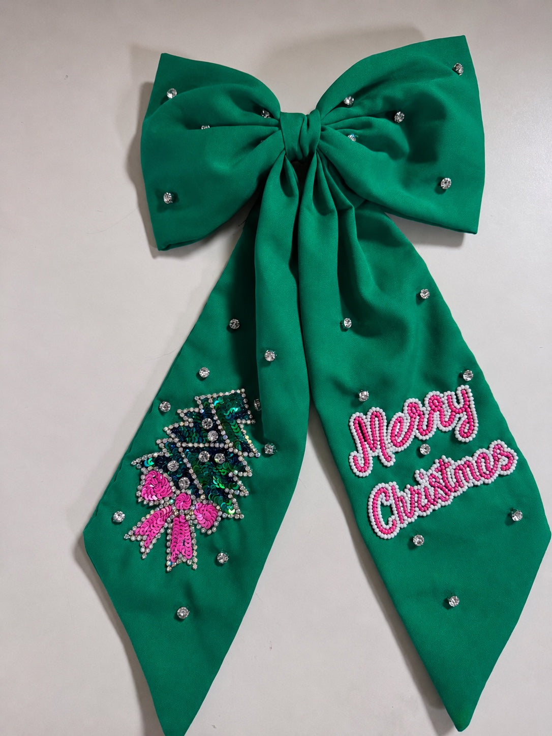 Green oversized Christmas embellished hair bow with jeweled Christmas tree and Merry Christmas details